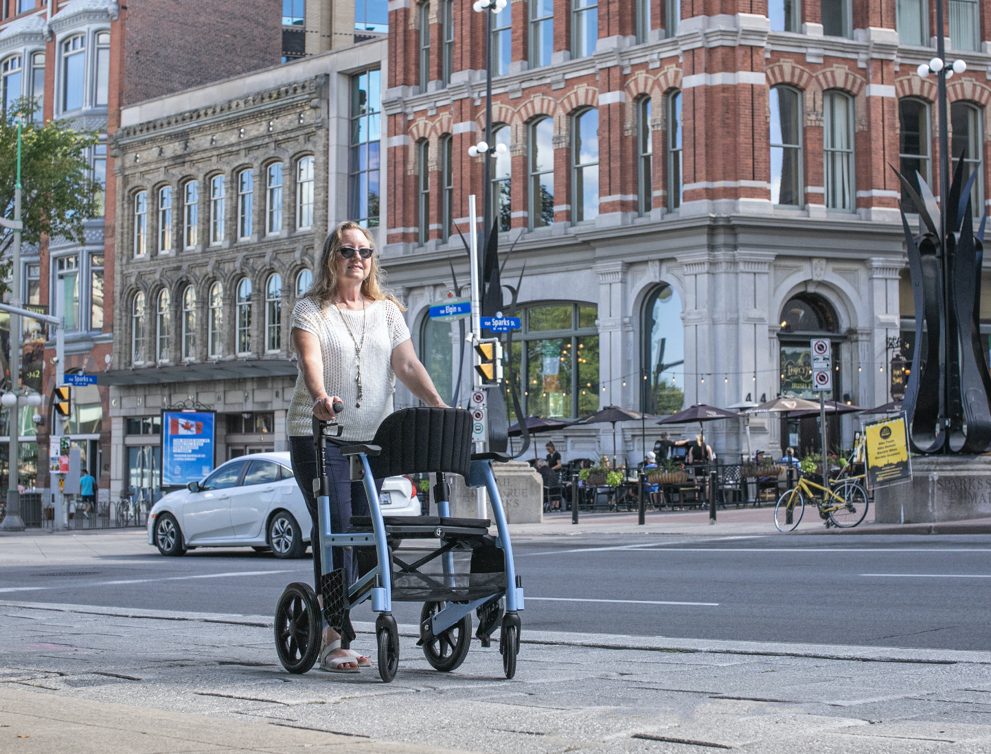 Triumph Prestige Rollator sky blue women walking on the sidewalk