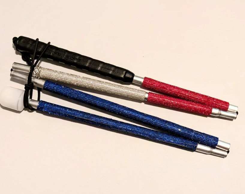 Cane folded. "The All-American" is a rhinestone cane that is ruby red at the top, silvery white in the middle, and blue at the end, mirroring the red, white & blue pattern representing the American flag.