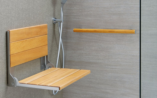 Wooden Bathroom Chair attached to a grey wall with a wooden grab bar.