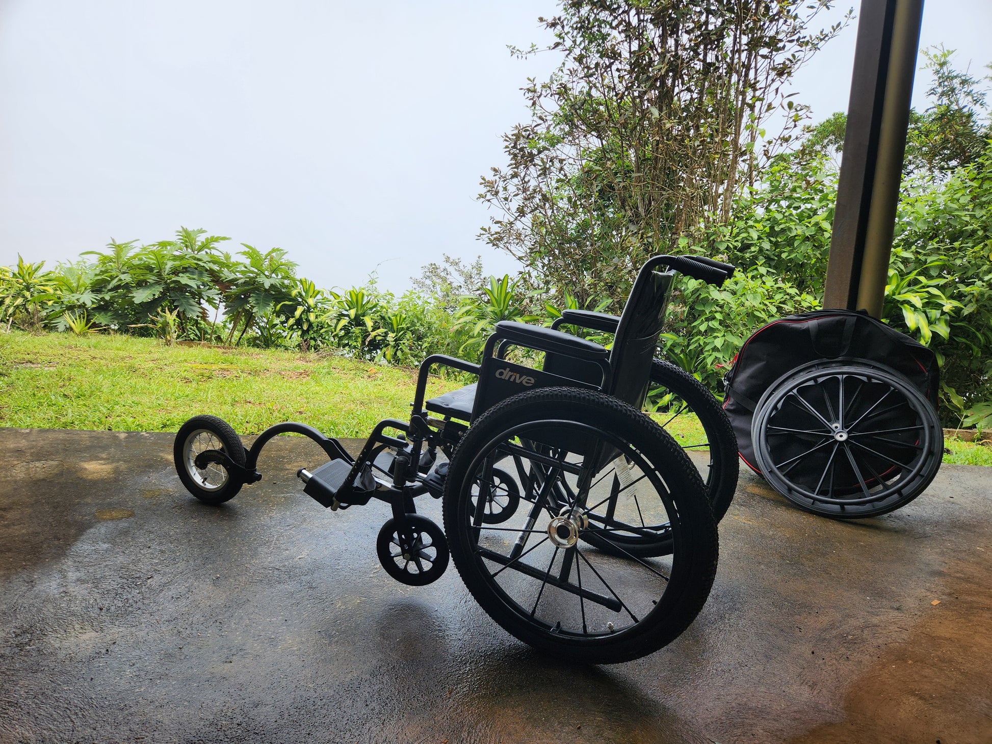 wheelchair on a concrete surface with greenery in the background