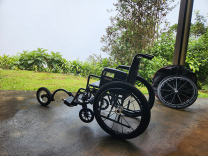 wheelchair on a concrete surface with greenery in the background