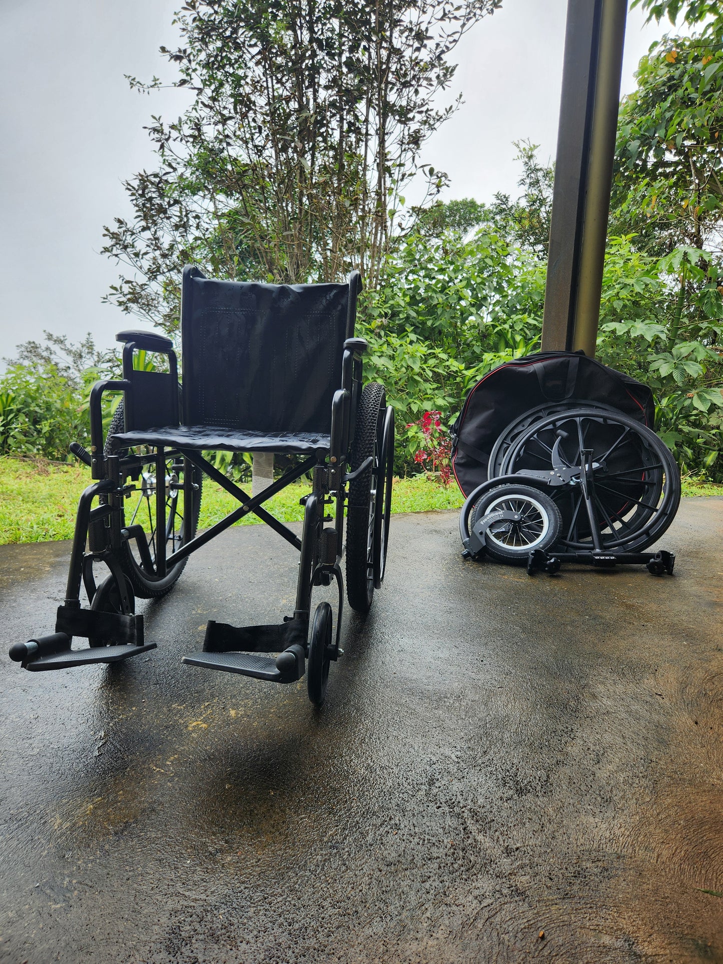 Manual wheelchair with spare wheels and freewheel sitting seperately.