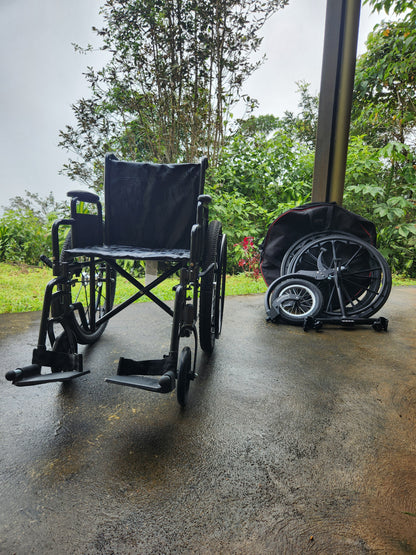 Manual wheelchair with spare wheels and freewheel sitting seperately.