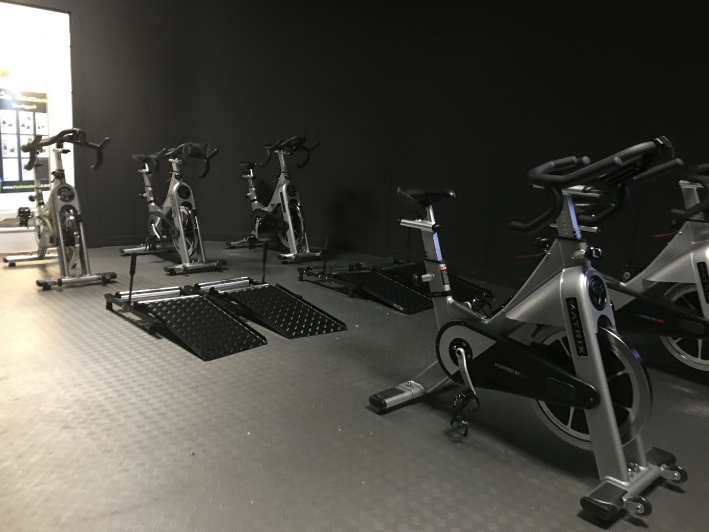 Invictus Active Trainer in the gym surrounded by spin bikes. 