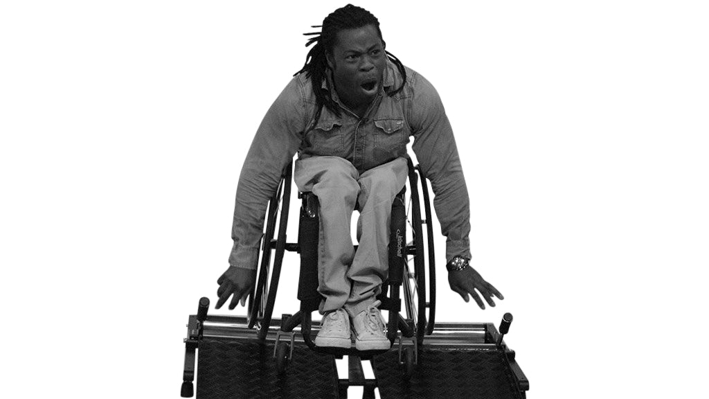 Wheelchair training roller with Man using it and moving very fast. View from a front angle.