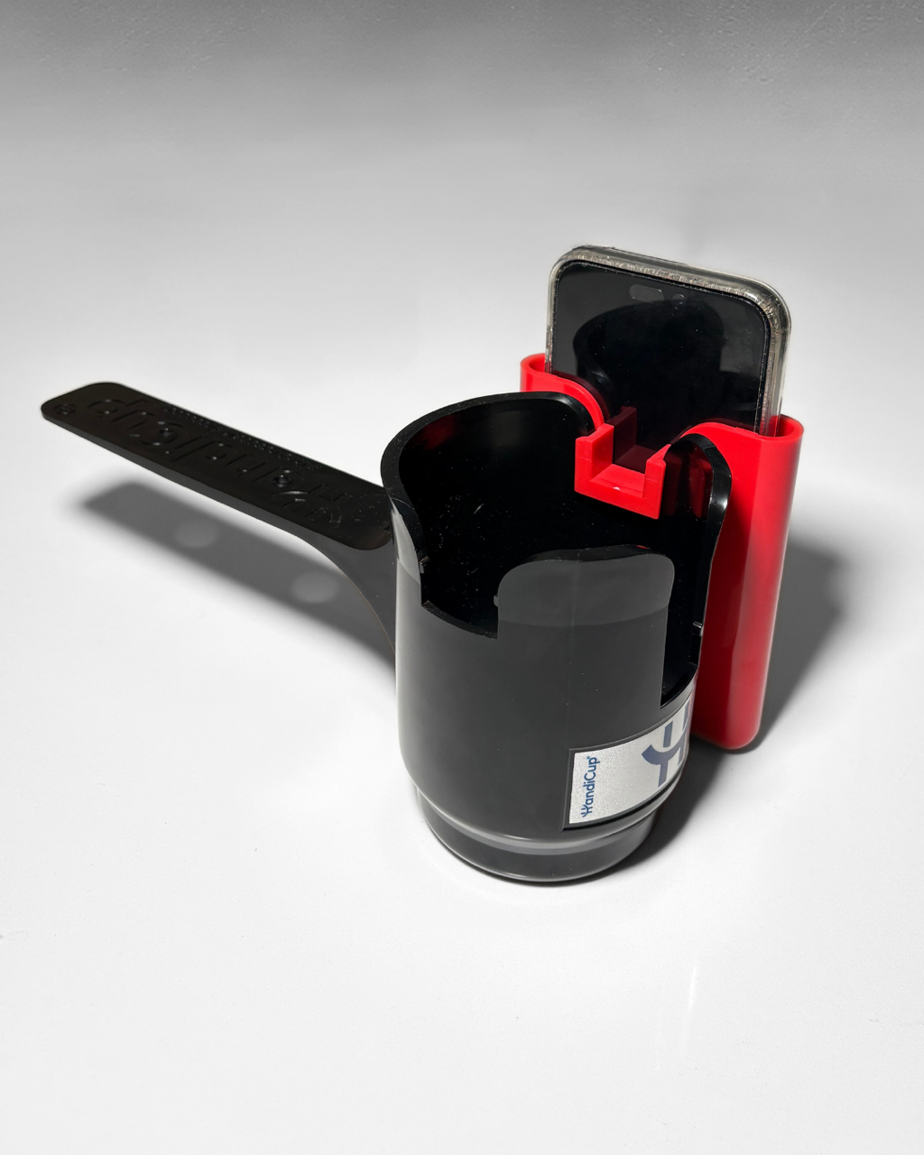 Phone holder attached to the wheelchair cup holder in the color red from the back